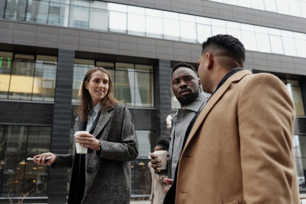 coworkers-taking-a-coffee-break-4427815 A group of diverse professionals discussing business during a coffee break outdoors.